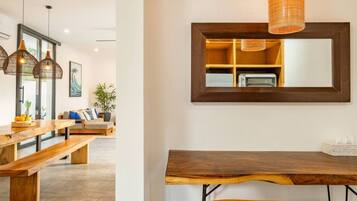 Un espace de restauration moderne avec une table en bois, des bancs et des luminaires suspendus.