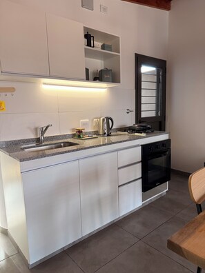 A modern kitchen with a built-in oven, a coffee maker, and a kettle. - Stanza II. Lovely 1-bedroom apartment with AC in enchanting Córdoba (Córdoba)