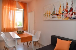Un coin repas avec une table, des chaises et un tableau accroché au mur.