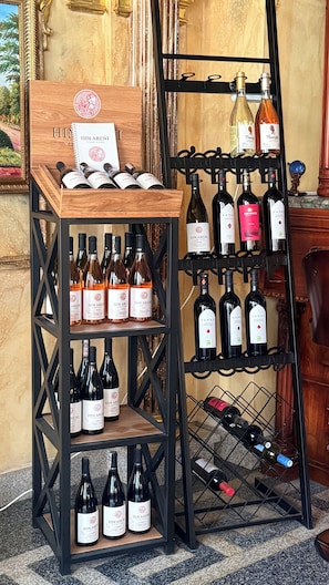 A wine display with multiple shelves and racks holding various bottles. - Alexandrapol Hotel Palace (Gyumri)