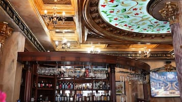 Un'elegante zona bar con dettagli del soffitto decorati e un soffitto in vetro ornamentale.