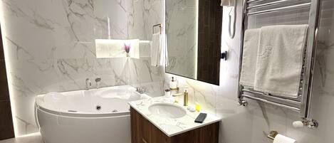 A modern bathroom with a freestanding bathtub, a vanity with a sink, and a large mirror.