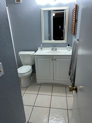 Ein Badezimmer mit Toilette, Waschbecken und Spiegel.
