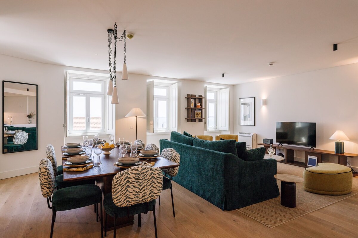 A modern living room with a dining area, a sofa set, a television, and a fireplace.