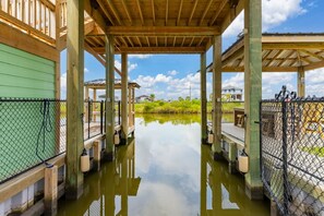 Une structure en bois couverte, avec un plan d’eau devant, le tout entouré d’une clôture.
