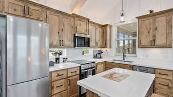 Una cocina moderna con gabinetes de madera, electrodomésticos de acero inoxidable y una isla grande.