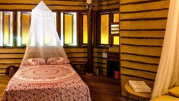 Une chambre avec un lit sous un dais, des murs en bois et une fenêtre donnant sur un beau paysage.
