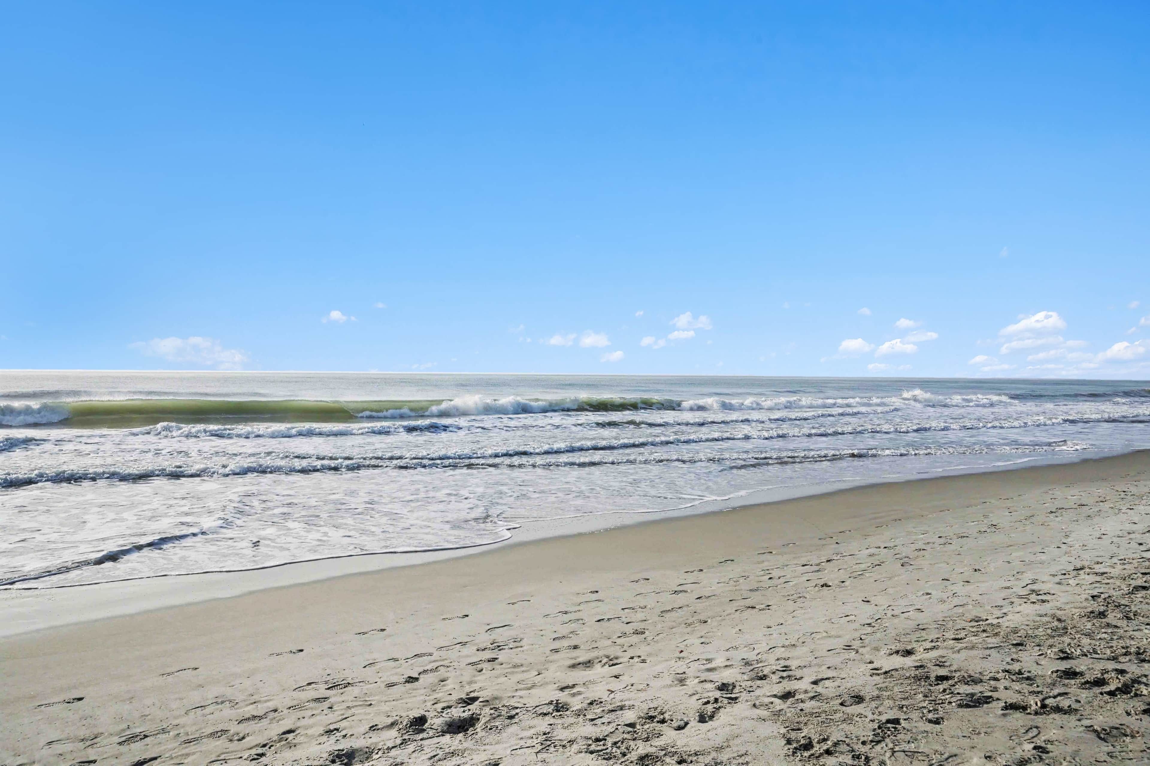 Ein Strand mit sandigem Ufer und Wellen.
