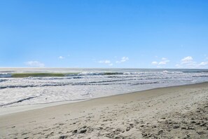 A beach with a sandy shore and waves. - Grand Strand Little Retreat (Garden City Beach)