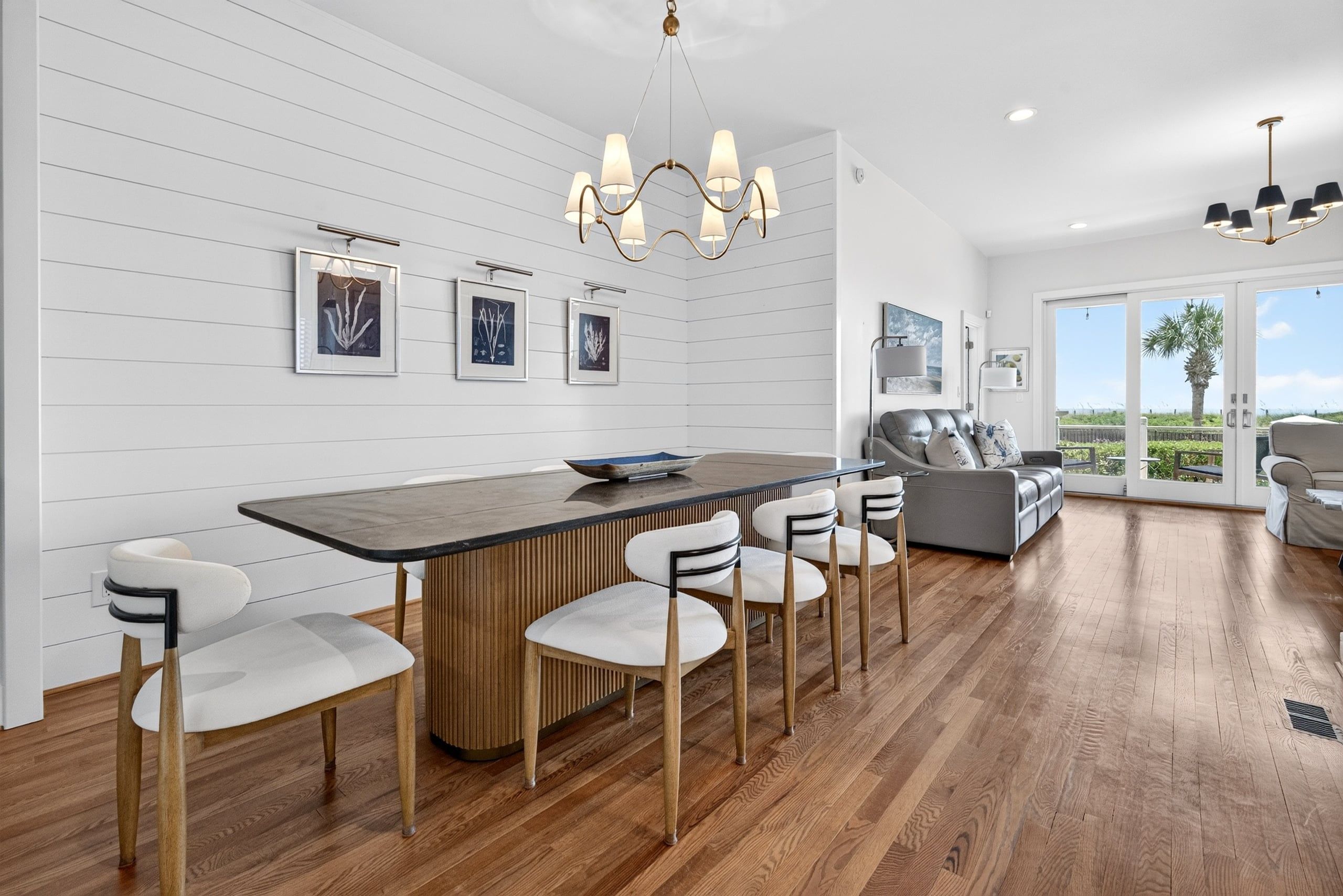 A modern kitchen with a central island, bar stools, and pendant lighting.