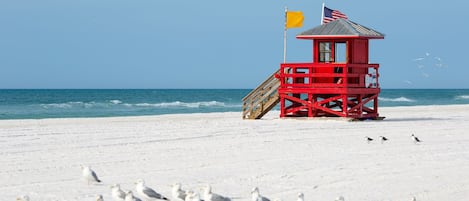 Une tour de surveillance avec un drapeau, sur une plage.