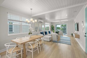A spacious living area with a dining table, white furniture, and large windows. - Luxury Pet Friendly Waterfront Home Private Pool & Dock in Resort Community Manatee Dreams at Hunters Point (Cortez)