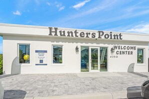 A building with the sign 'Hunters Point Welcome Center' and a phone number. - Luxury Pet Friendly Waterfront Home Private Pool & Dock in Resort Community Manatee Dreams at Hunters Point (Cortez)