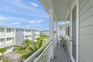A balcony with a view of adjacent buildings, a small table with chairs, and a clear sky. - Luxury Pet Friendly Waterfront Home Private Pool & Dock in Resort Community Manatee Dreams at Hunters Point (Cortez)