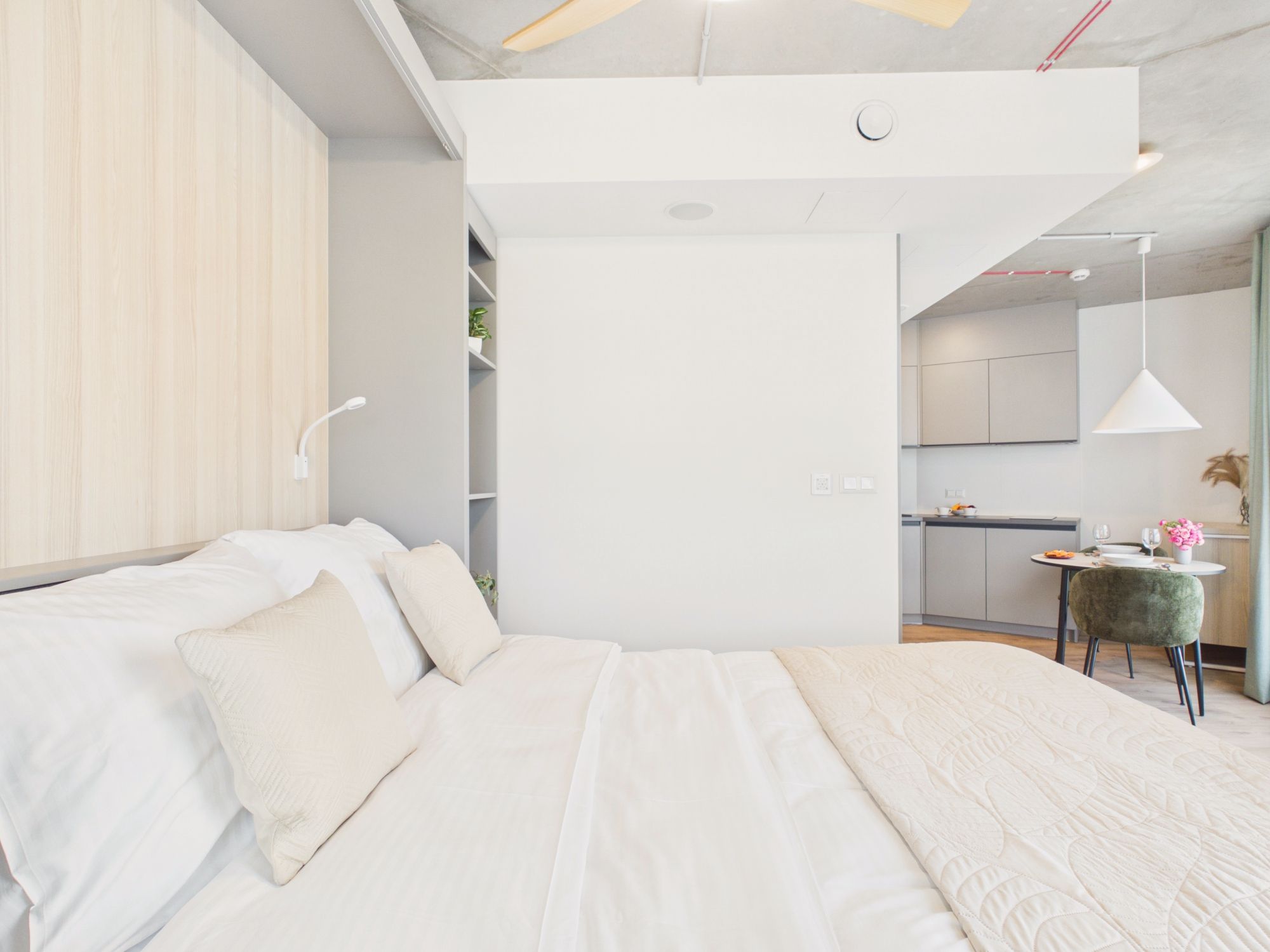 Une chambre moderne avec un grand lit, un bureau et un coin repas.