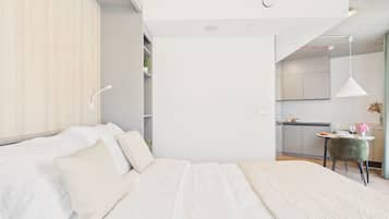 Une chambre moderne avec un grand lit, un bureau et un coin repas.