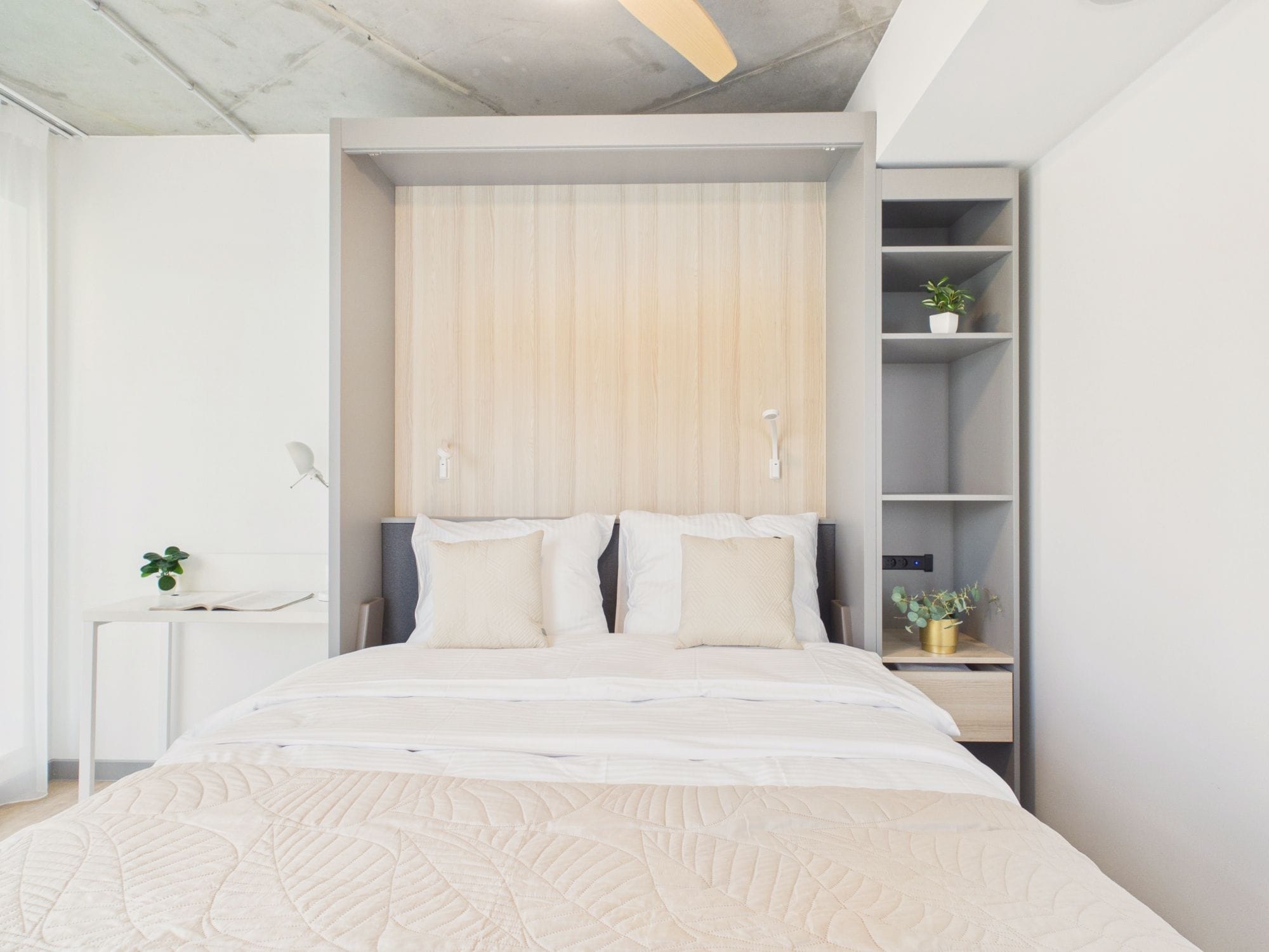 Un dormitorio moderno con una cama grande, estanterías empotradas y un diseño minimalista.