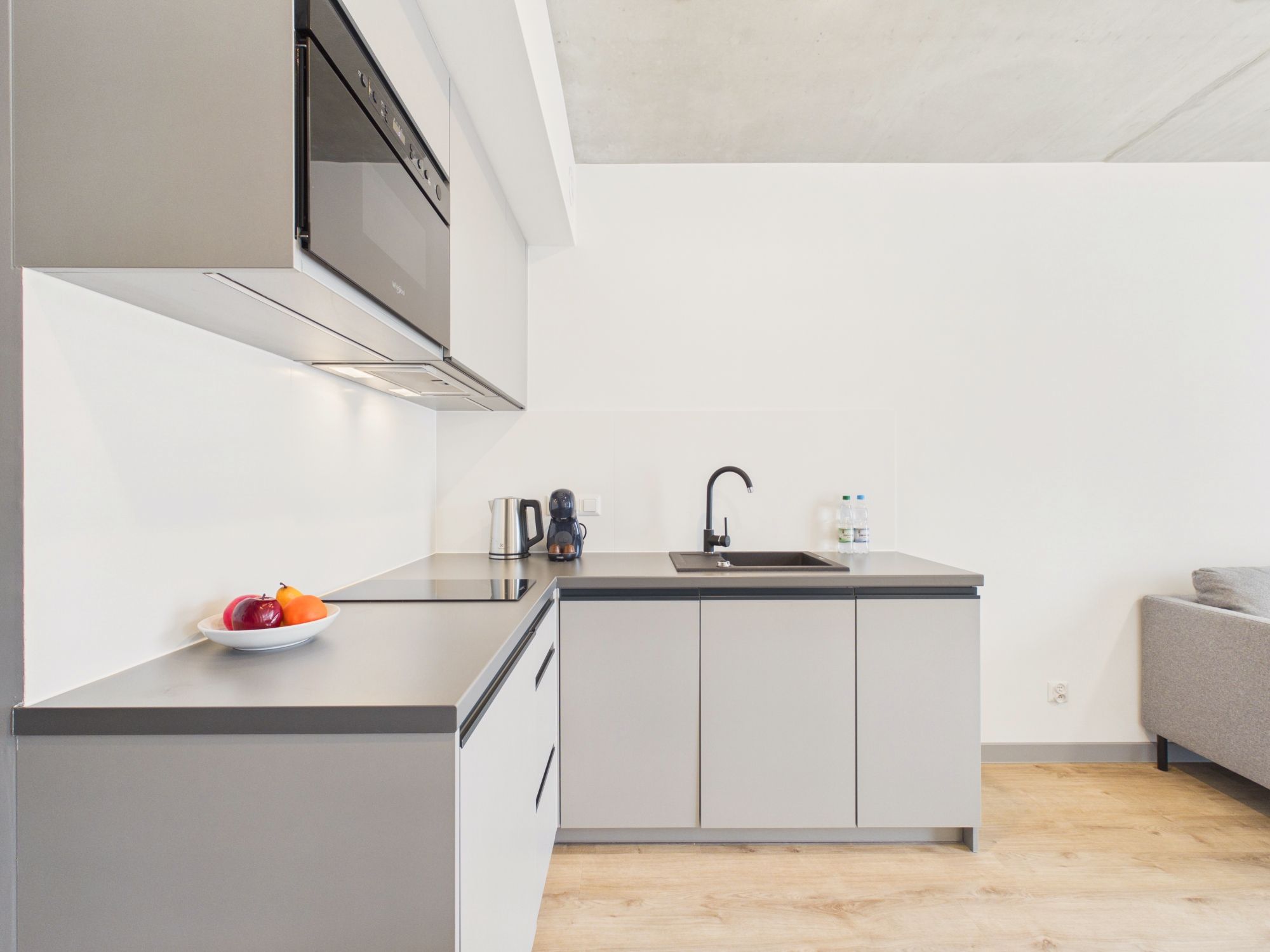 A modern kitchen with a built-in stove, a sink, and a coffee maker.