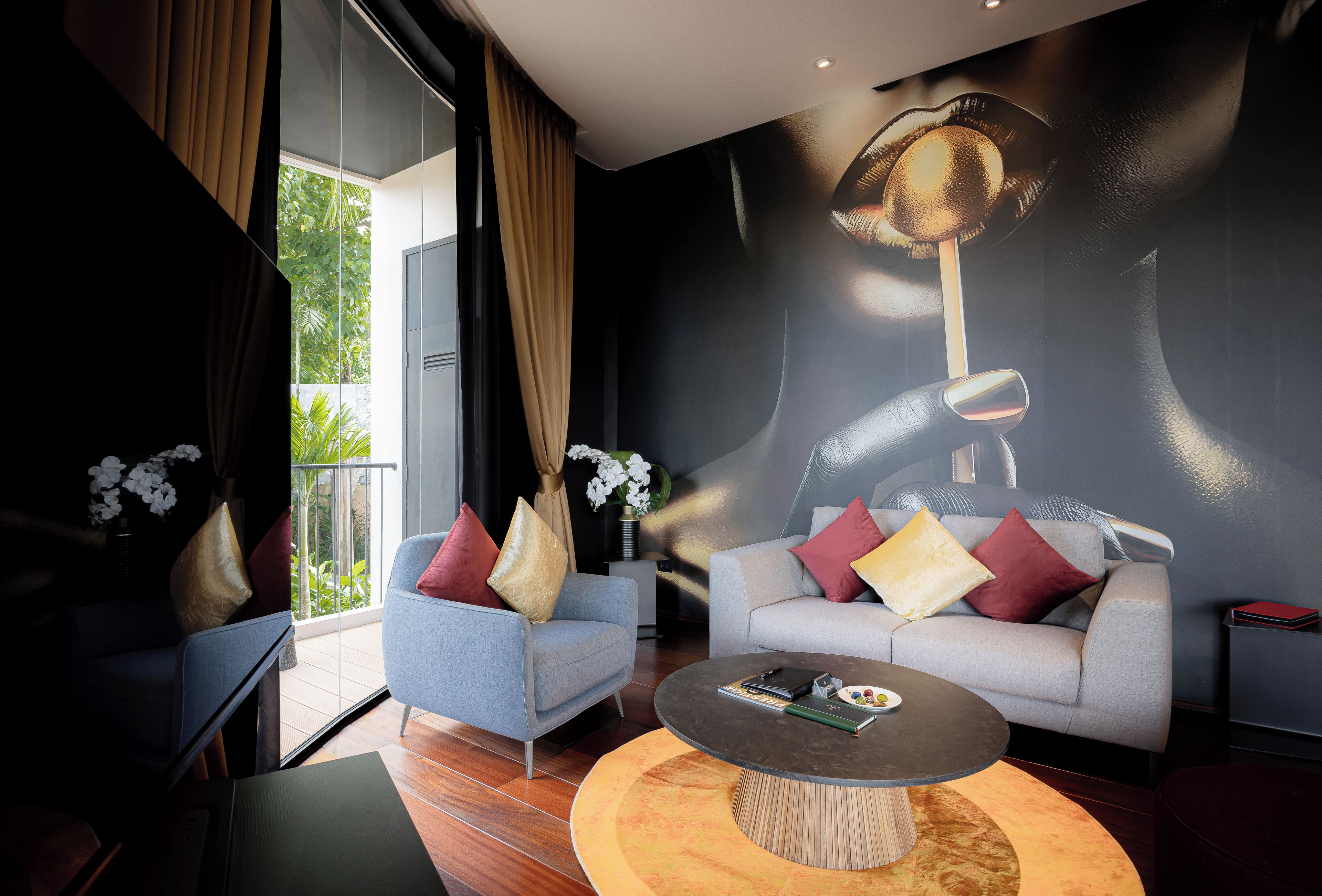 Una sala de estar moderna con un sofá, sillones, una mesa de centro y un mural grande en la pared.