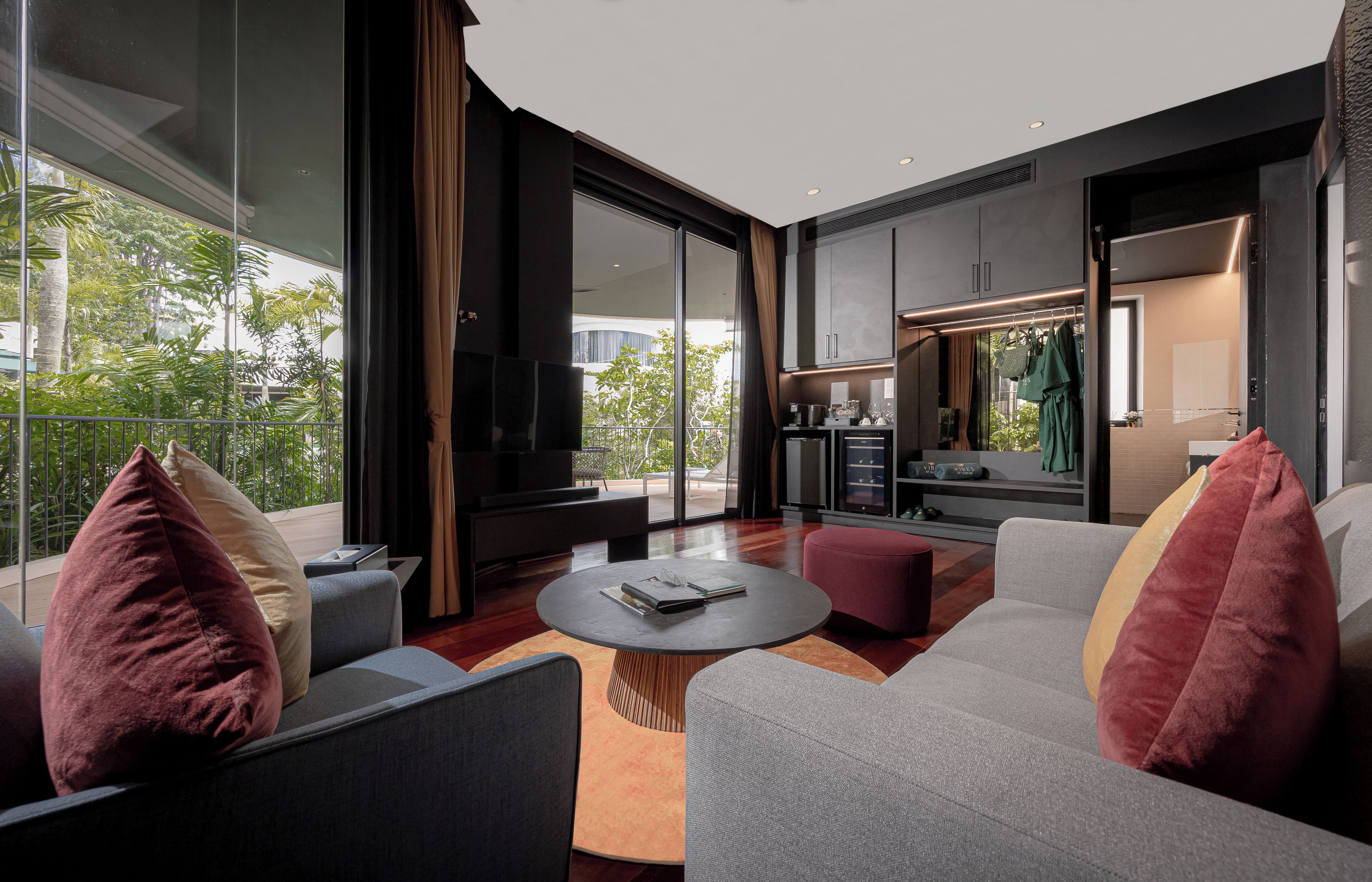 A modern living room with a large TV, comfortable seating, and a view of the outdoors.