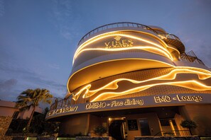 A building with a curved facade, illuminated signage for 'Vibes of Nature' and 'EMO Lounge,' and a sign for 'Odey - Café & Bakery.' - Vibes of Nature Phuket (Phuket)