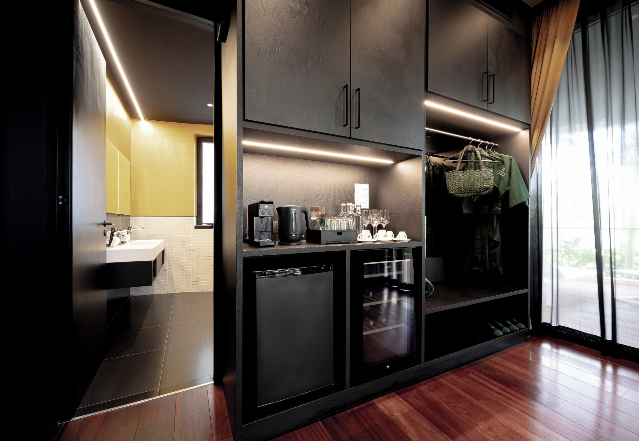 A modern kitchen with a built-in dishwasher, a coffee machine, and a wine cooler.