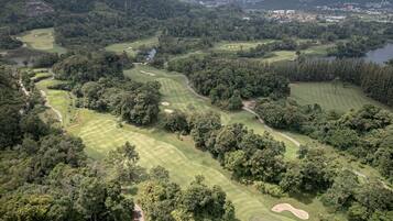 An aerial view of a golf course with multiple fairways, sand bunkers, and water hazards.