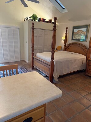 A bedroom with a four-poster bed, a smaller bed, a desk, and a chair. There is a ceiling fan, a window, and a framed picture on the wall. - Come for the Quiet......Stay for the Luxurious Amenities and the convenience (Apache Junction)
