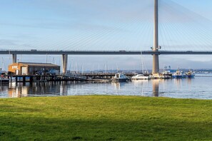 Eine Brücke mit einem Hafen im Vordergrund, mit Booten und einem Gebäude.