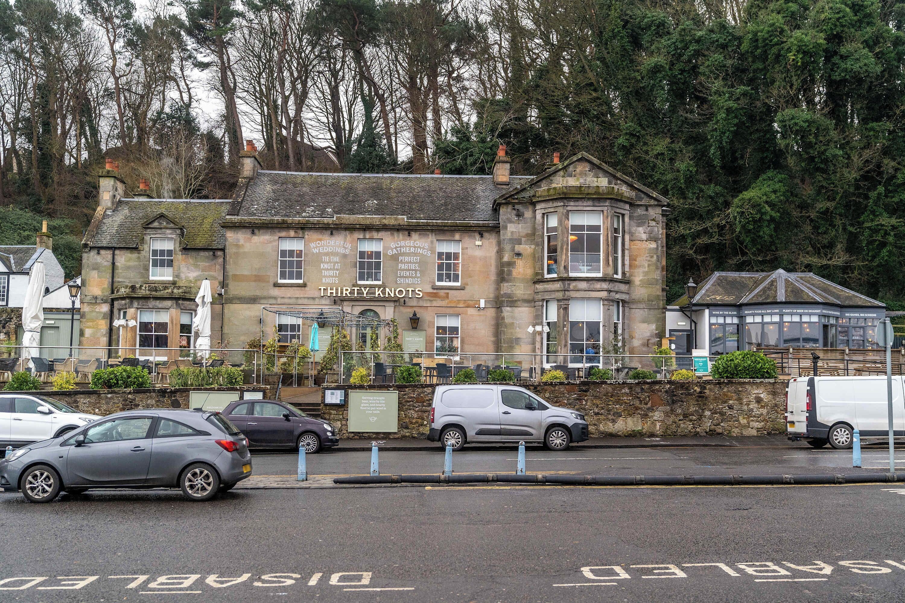A historic building with a sign for 'Thirty Knots' indicating it may be a pub or restaurant.