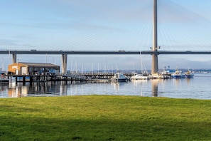 A bridge with a marina in the foreground, featuring boats and a building. - Elegant Studio at The Brewery (Queensferry)