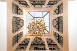 A grand atrium with a central chandelier and multiple balconies. - Elegant 3-bedroom Riad with AC perfect for relaxing stays (Marrakech)