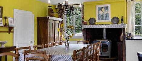 A dining area with a table set for six, surrounded by wooden chairs.