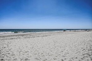 Ein Strand mit blauem Himmel und ruhiger See.