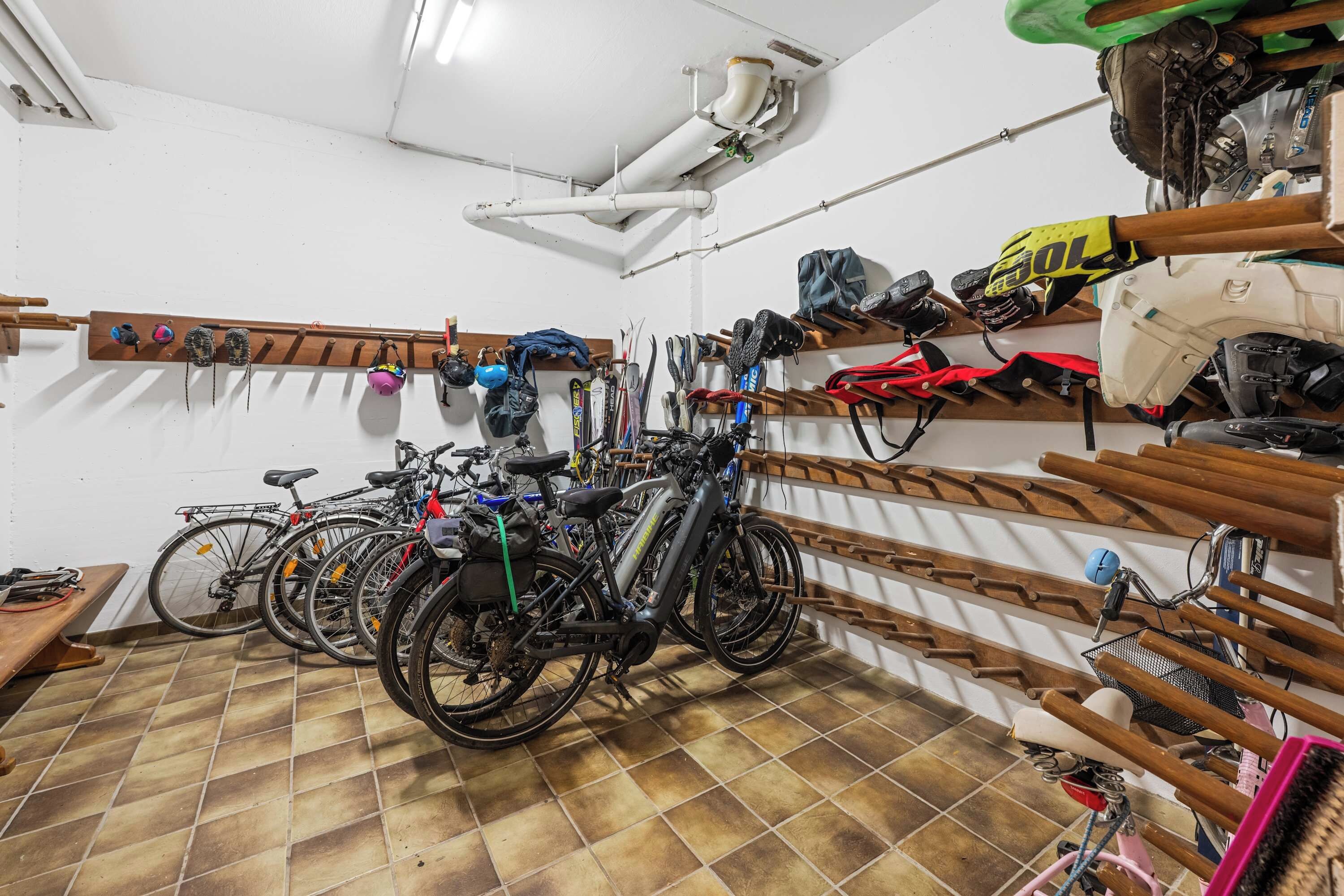 Ein Fahrradabstellraum mit mehreren Fahrrädern und Helmen.