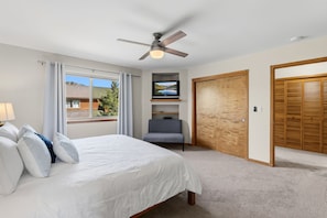 A bedroom with a bed, a chair, a television, a ceiling fan, and a wardrobe. - Dillon 3BR Mountain Townhome | Hot Tub, Sauna, and near Breck, Keystone (Dillon)