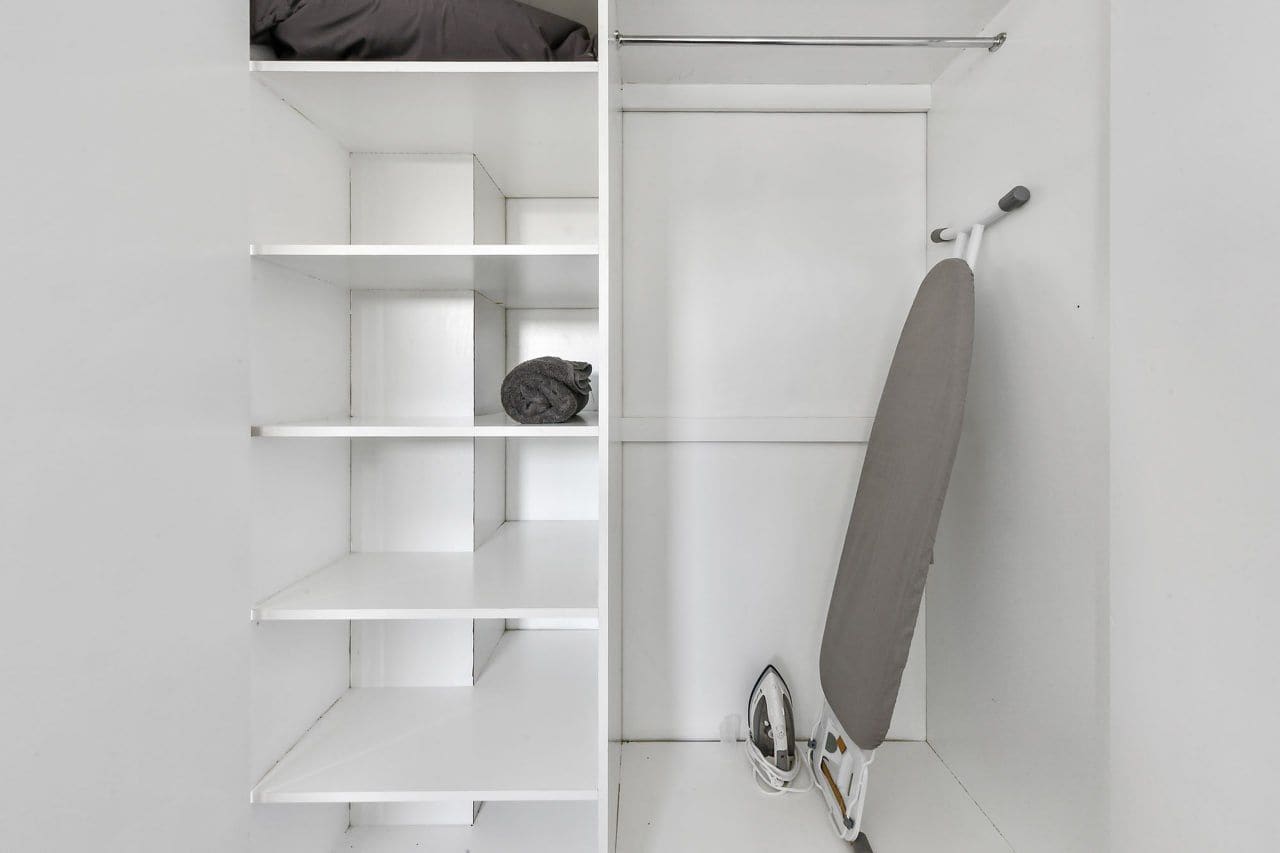 A white closet with shelves and a hanging rod.