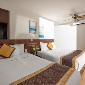 Habitación de hotel con dos camas, ventilador de techo y ventana con vistas.