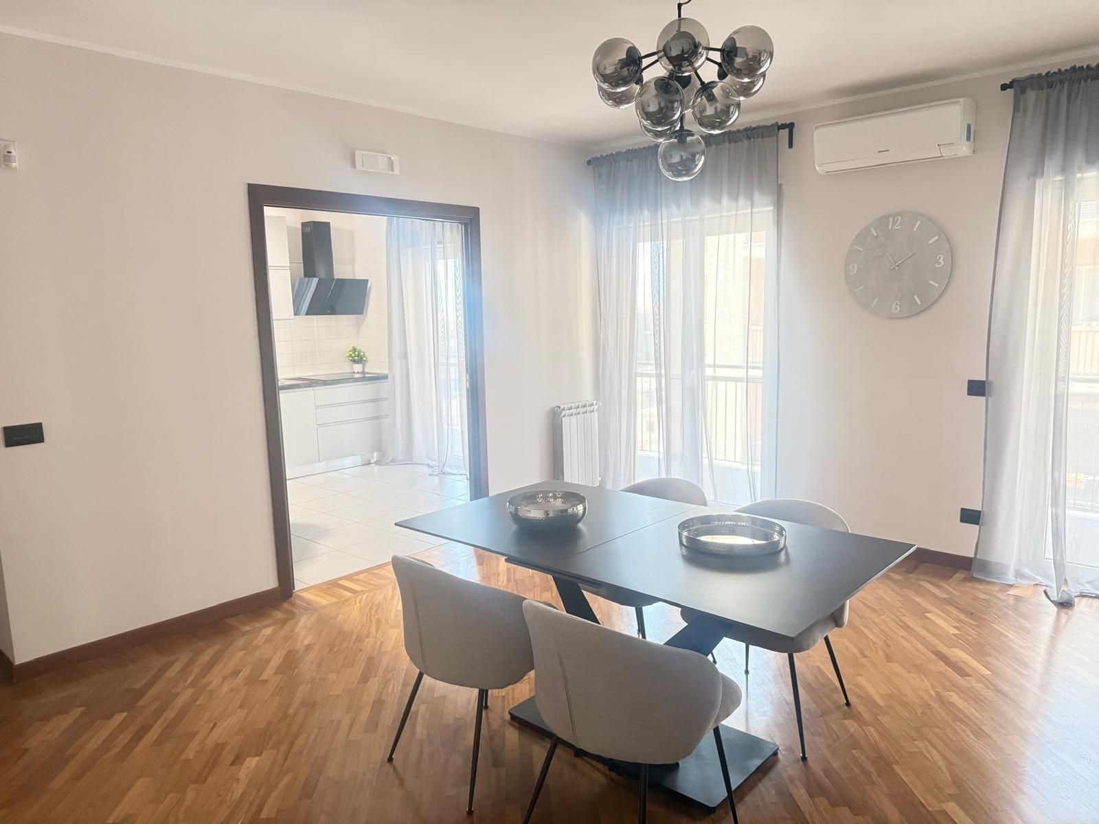 A dining area with a table, chairs, and a chandelier.