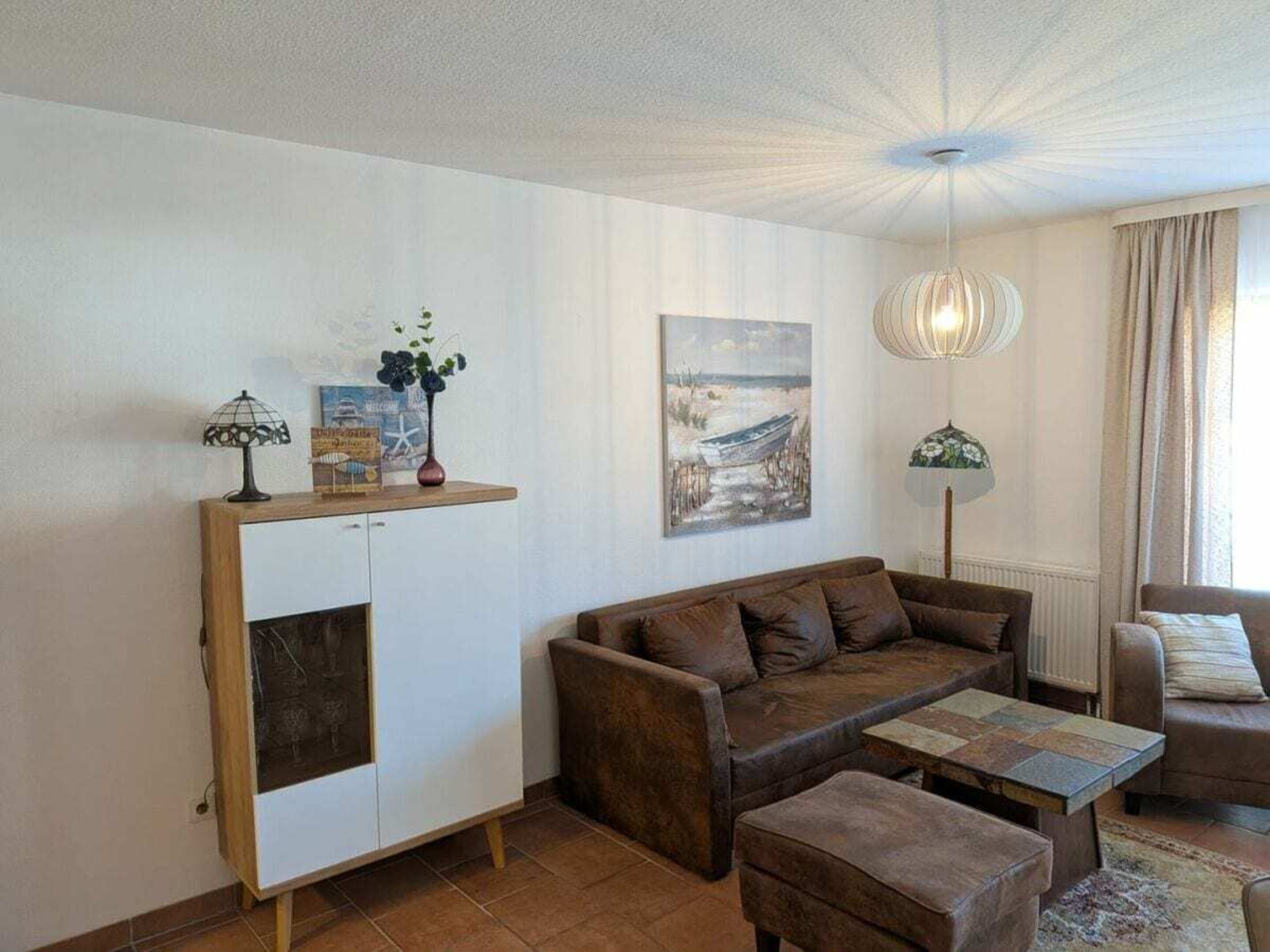 A living room with a sofa, a coffee table, a cabinet, and a painting on the wall.