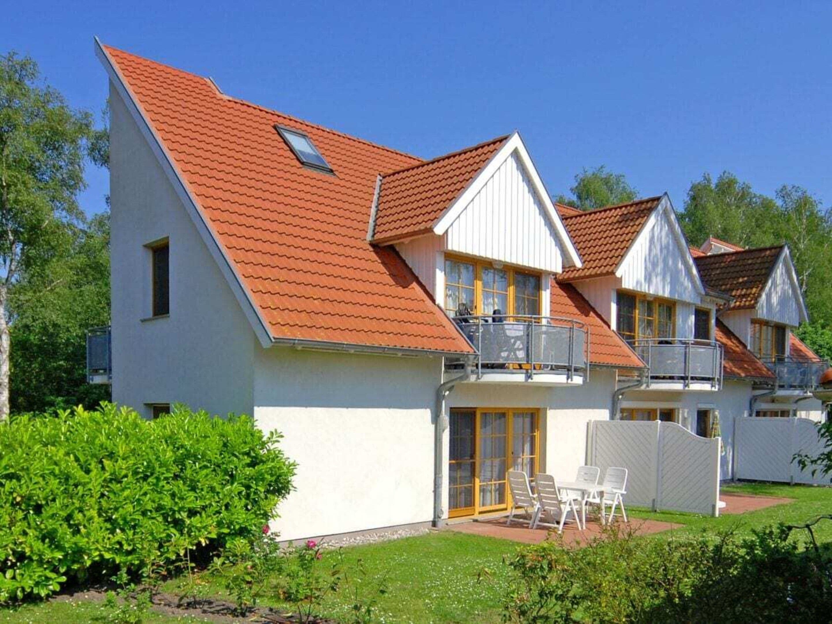 Een rij witte huizen met rode daken en balkons.