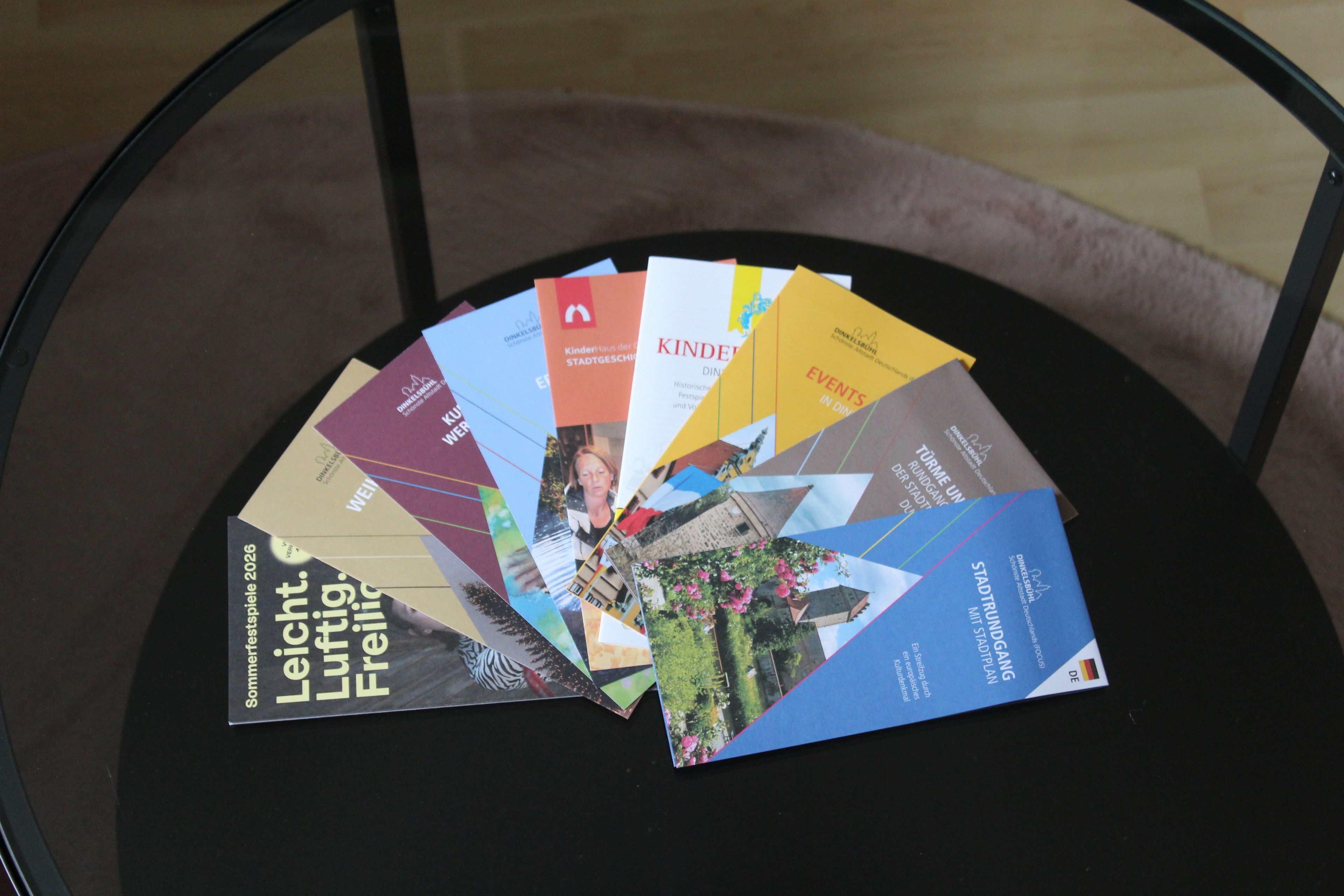 A collection of brochures on a round table.