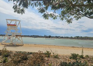 Un torreta de socorristes a la platja, amb un cel serè i aigua tranquil·la.