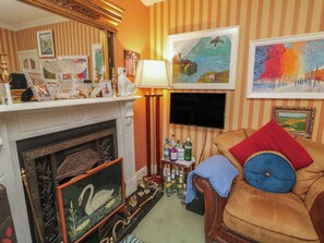 A cozy living room with a fireplace, a television, and various decorative items. - BRUCKLESS REST FINE COUNTRY LIVING B&B in Bruckless, County Donegal (Bruckless)
