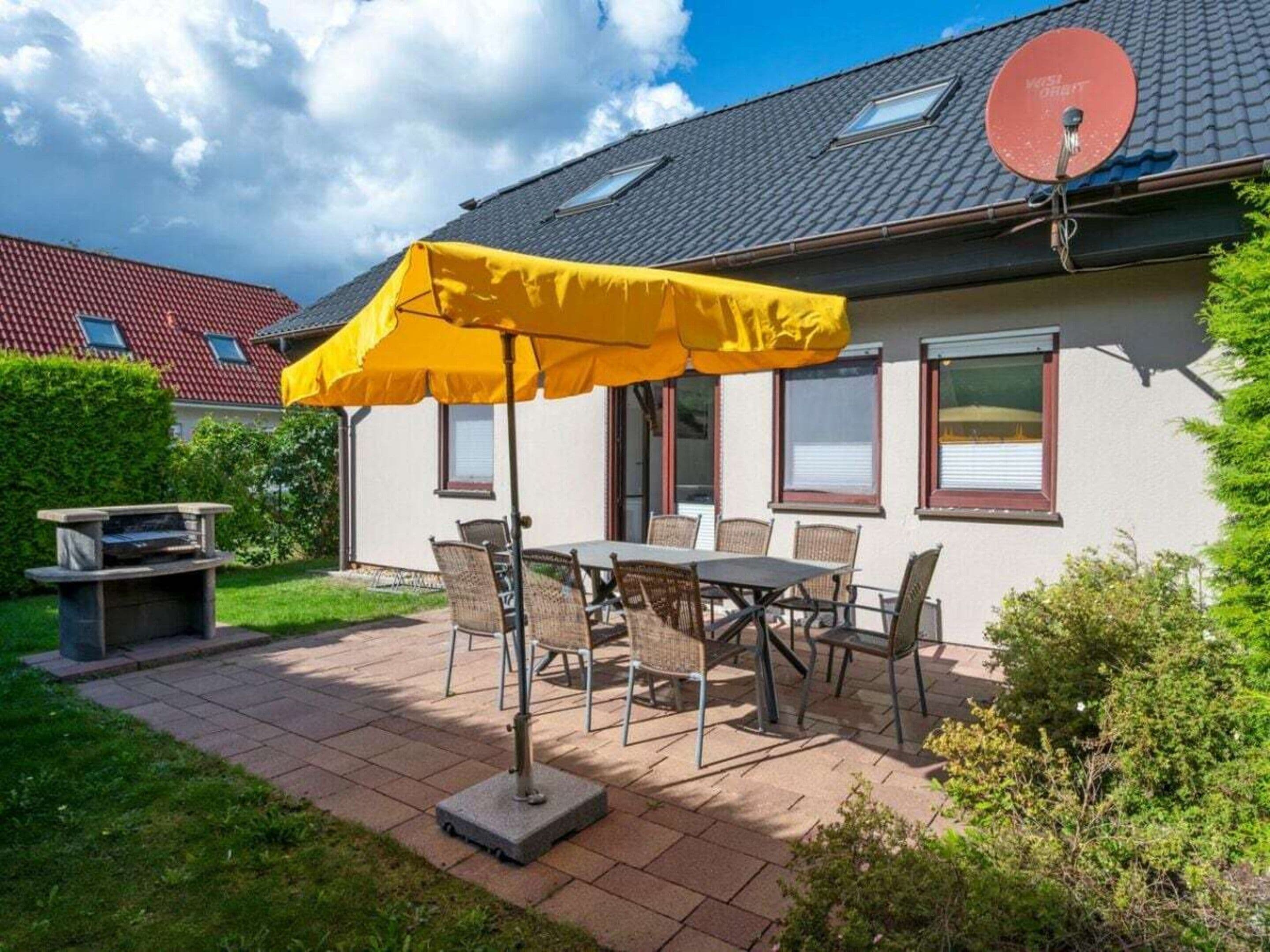 Ein Haus mit Terrasse, Gartenmöbeln und einer Satellitenschüssel.