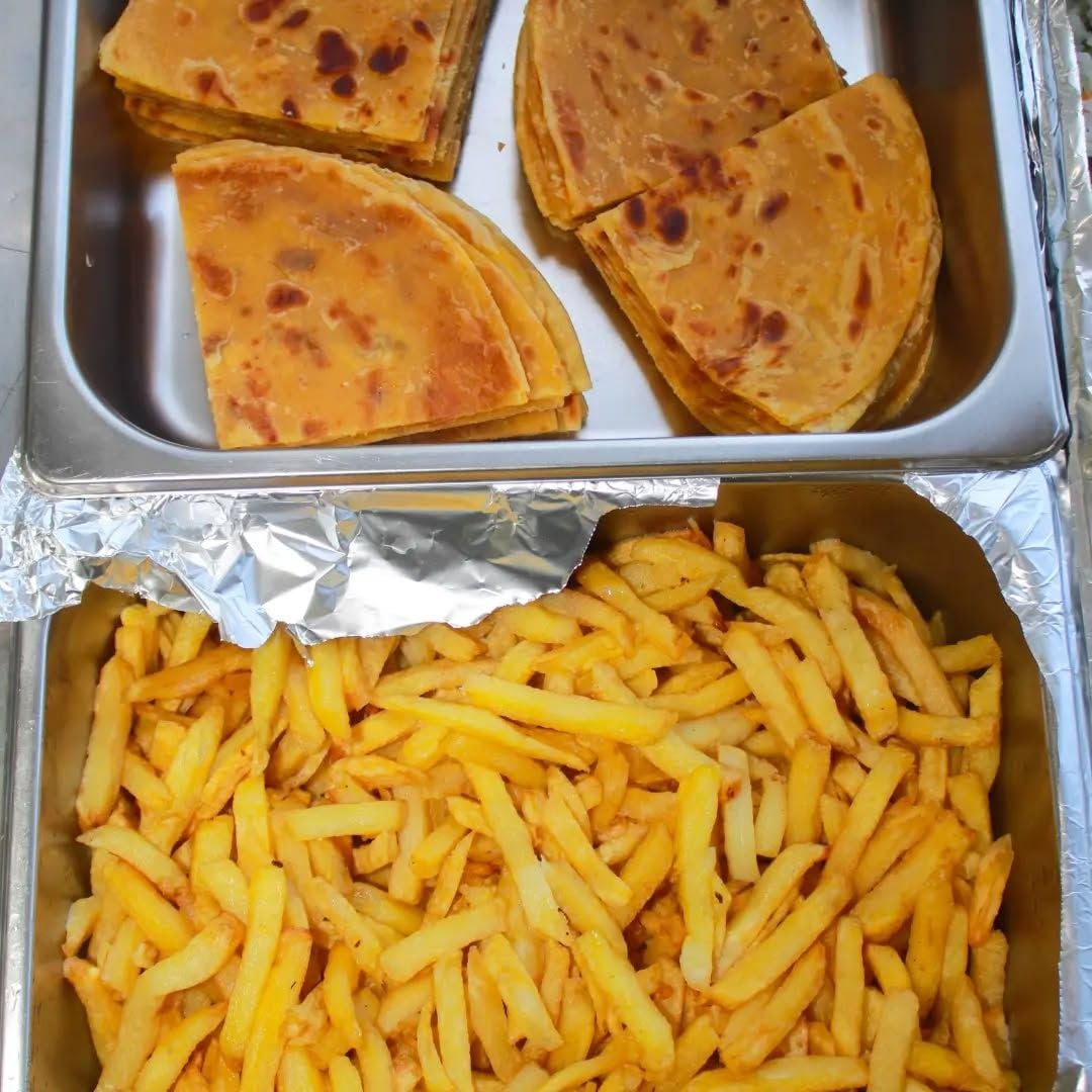 A tray with four pieces of flatbread and a large portion of French fries.