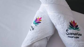 Two white towels with embroidered logos and text, placed on a flat surface.