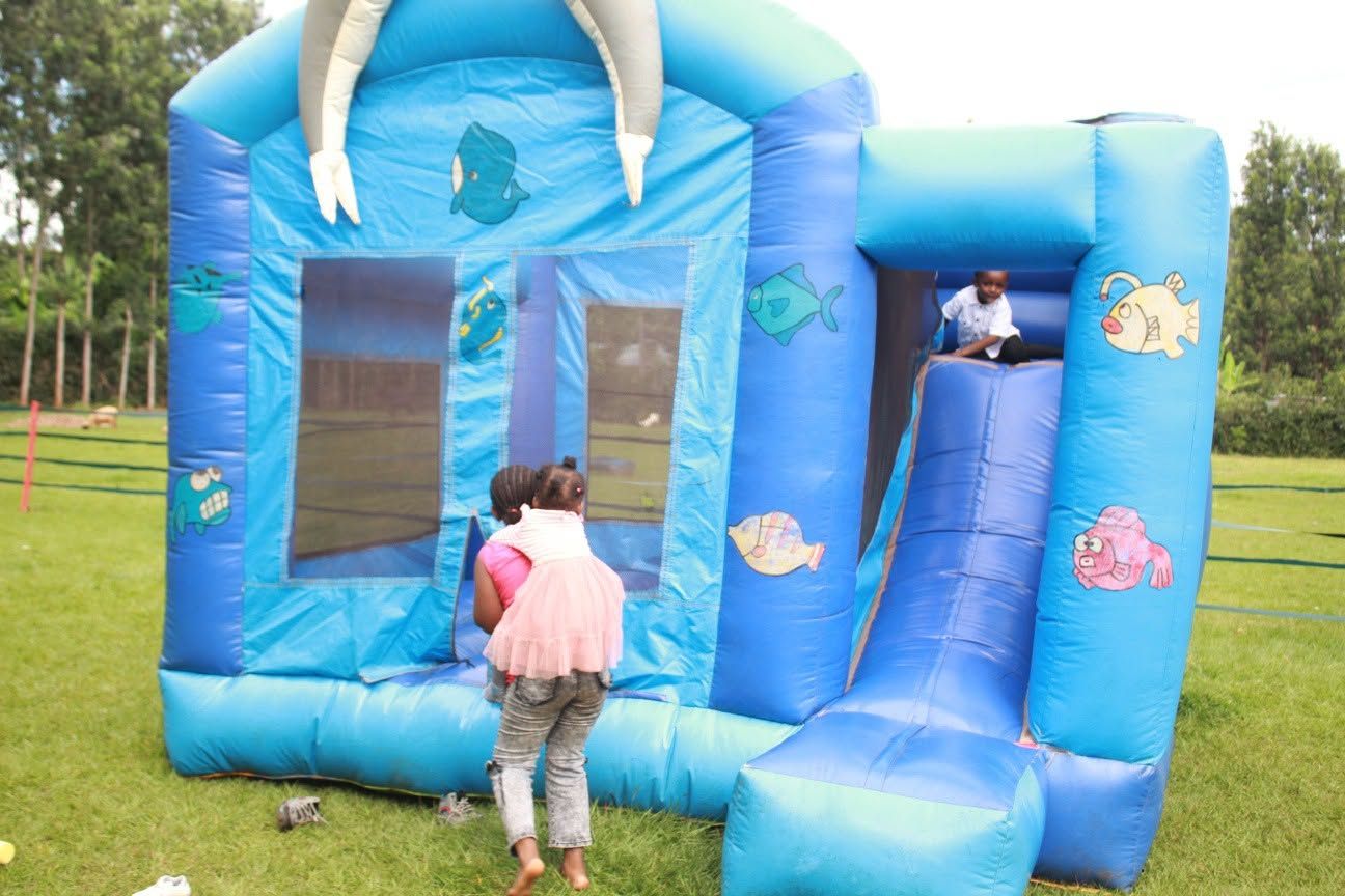 A blue inflatable play structure with slides and a climbing wall, designed for children.