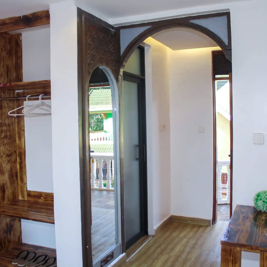 Un pasillo con un banco de madera, perchero y puerta que da al exterior.
