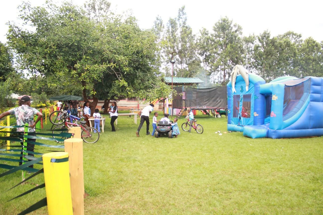 An outdoor area with a blue inflatable play structure, bicycles, and a picnic table.